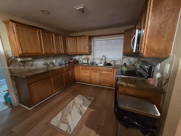 a kitchen with stainless steel appliances granite countertop sink stove top oven and cabinets