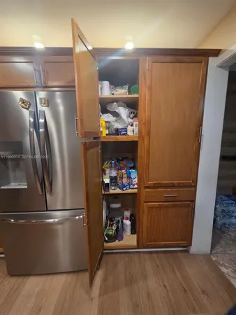 a kitchen with a refrigerator and a wooden floor