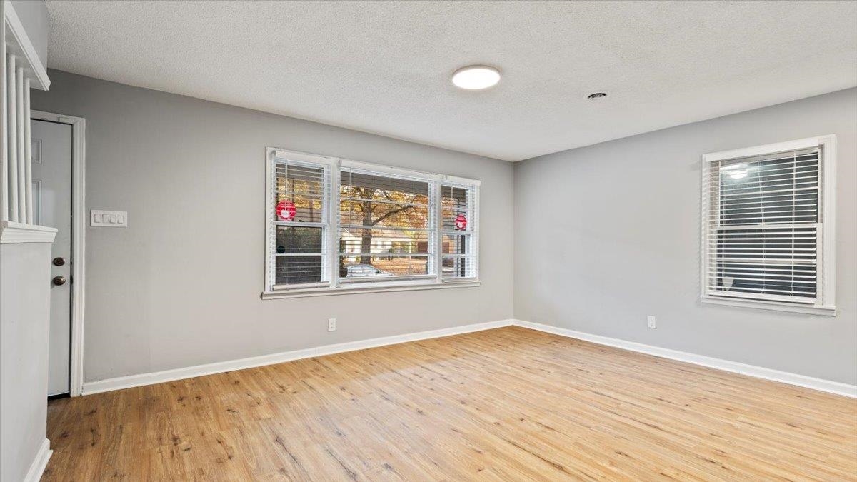 3817 Cazassa Road Memphis, TN 38116 - Photo 7 of 22 a view of an empty room with wooden floor and a window