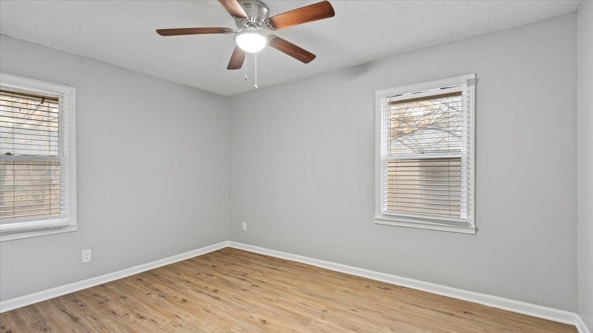 3817 Cazassa Road Memphis, TN 38116 - Photo 9 of 22 a view of an empty room with wooden floor and a window