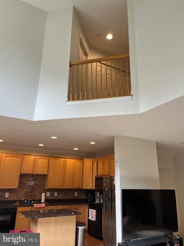 a view of an empty room with wooden floor and a fireplace