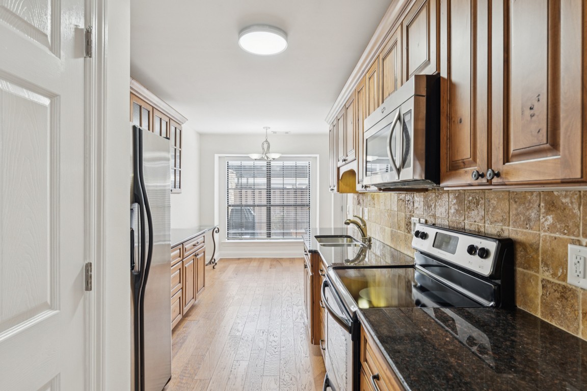 8552 Sawyer Brown Road Nashville, TN 37221 - Photo 9 of 25 a kitchen with stainless steel appliances granite countertop a refrigerator a stove and a sink with wooden floor