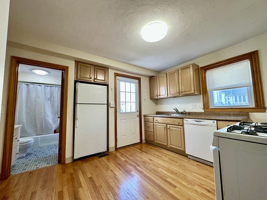 5 Rifle Court, Unit 5 Watertown, MA 02472 - Photo 2 of 14 a kitchen with granite countertop a refrigerator stove top oven and sink