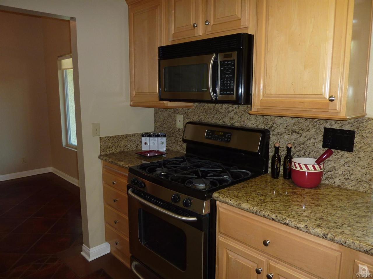192 Wrangler Road Simi Valley, CA 93065 - Photo 10 of 40 a kitchen with granite countertop a stove and a wooden floor