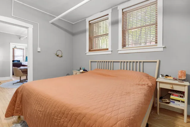 a bed sitting in a bedroom next to a window