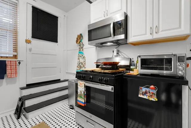 a kitchen with stainless steel appliances granite countertop a stove top oven microwave and cabinets