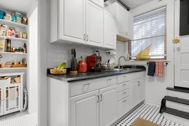 a kitchen with stainless steel appliances white cabinets and a window