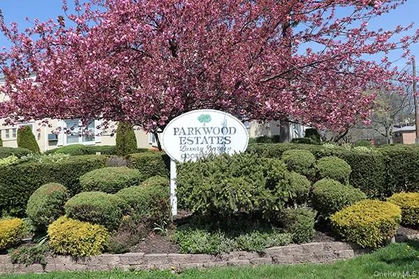 a sign that is sitting in front of a tree