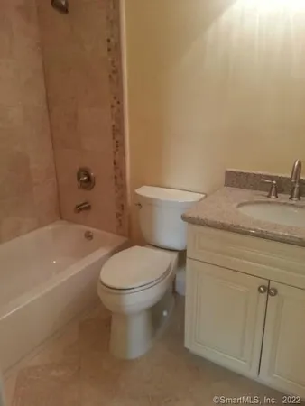 a bathroom with a granite countertop toilet a sink and bathtub