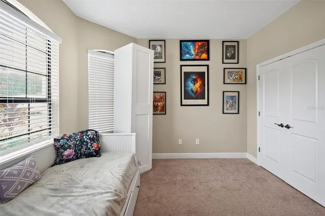 a bathroom with a granite countertop toilet a sink a shower curtain and a large mirror