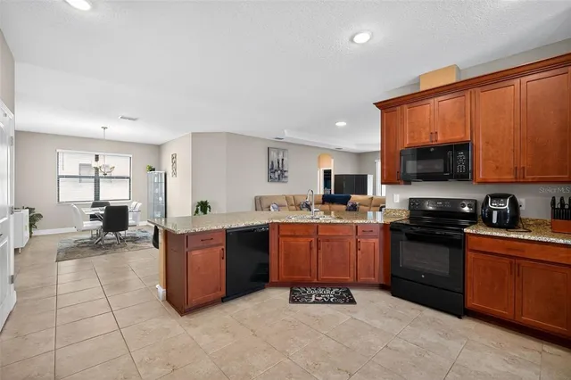 a large kitchen with stainless steel appliances granite countertop a stove and a sink