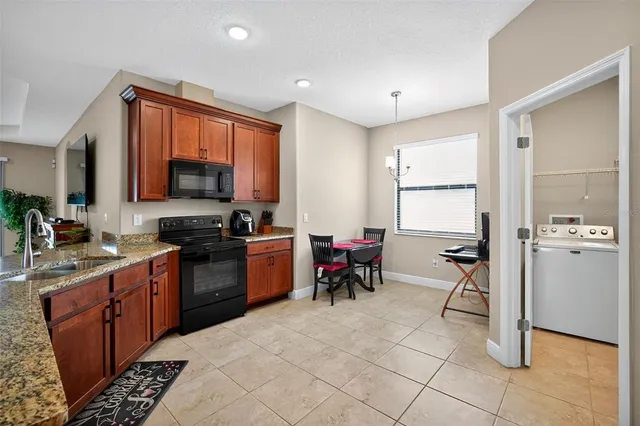 a kitchen with a sink a counter top space appliances and cabinets