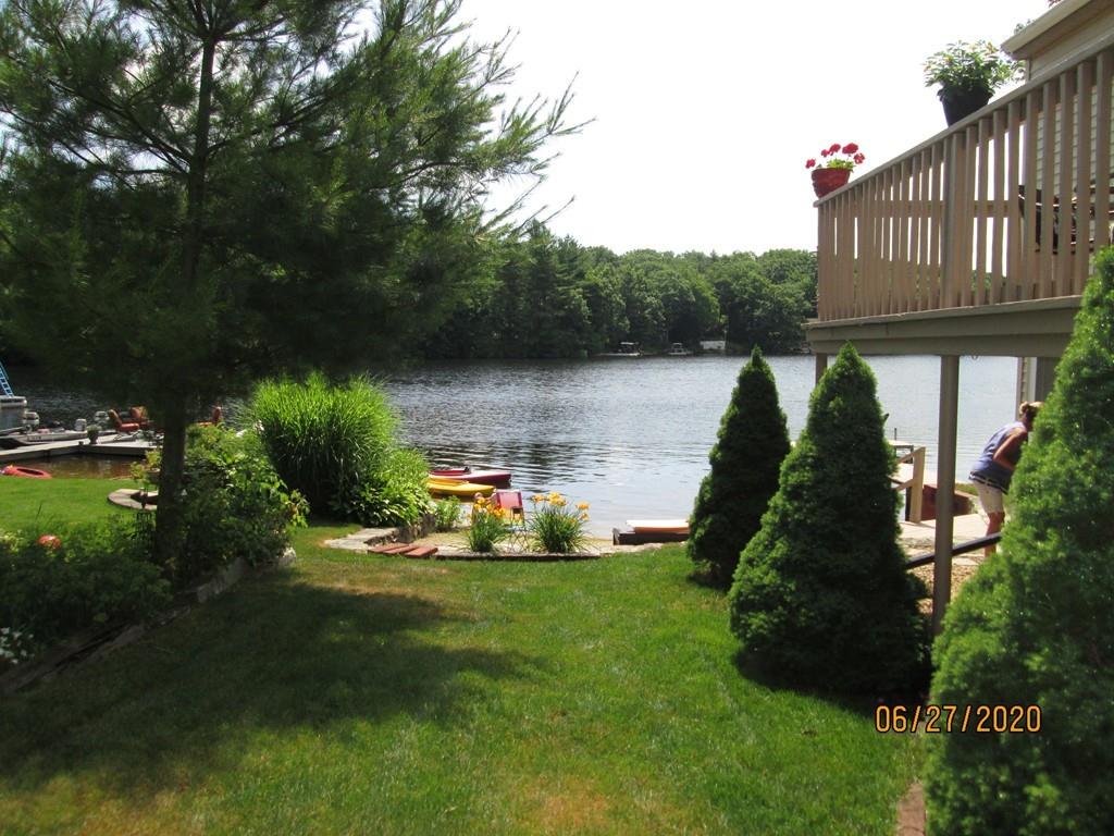 a backyard of a house with table and chairs potted plants and large tree