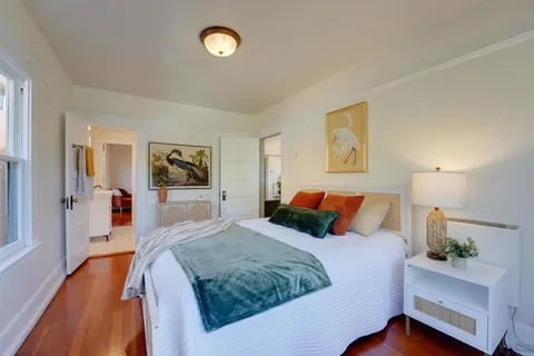 a bedroom with a large bed and a wooden floor