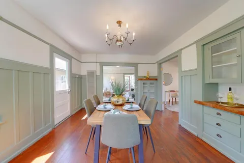 a view of a dining room with furniture a chandelier and wooden floor