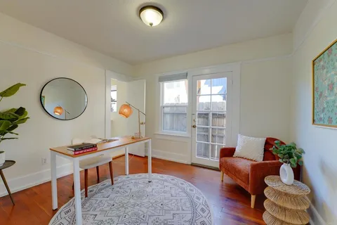 a living room with furniture and a mirror