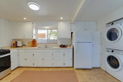 a view of a kitchen with a sink stove and cabinets
