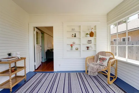 a view of a bedroom with baby bed and windows