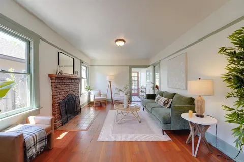 a living room with fireplace furniture and a wooden floor