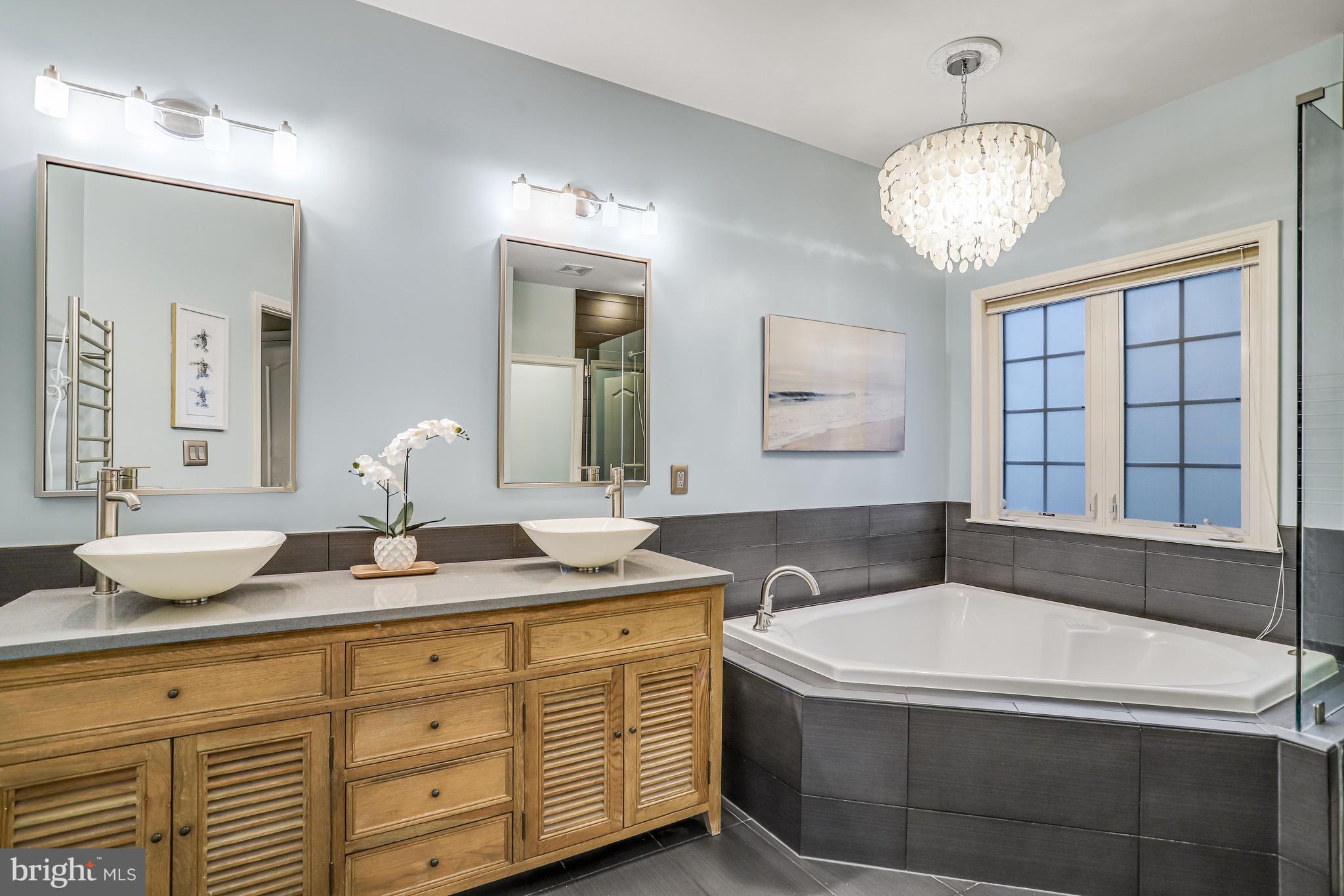 21625 Merion Street Ashburn, VA 20147 - Photo 11 of 80 a bathroom with a granite countertop sink a large mirror a bathtub and next to a window