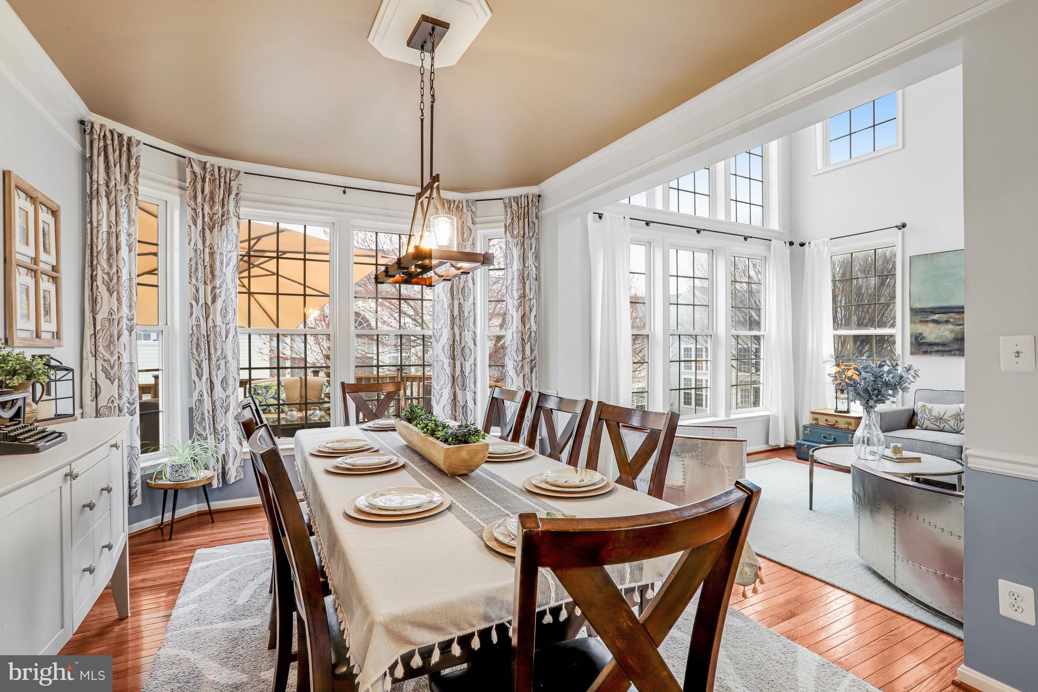 21625 Merion Street Ashburn, VA 20147 - Photo 33 of 80 a view of a dining room with furniture large windows and wooden floor