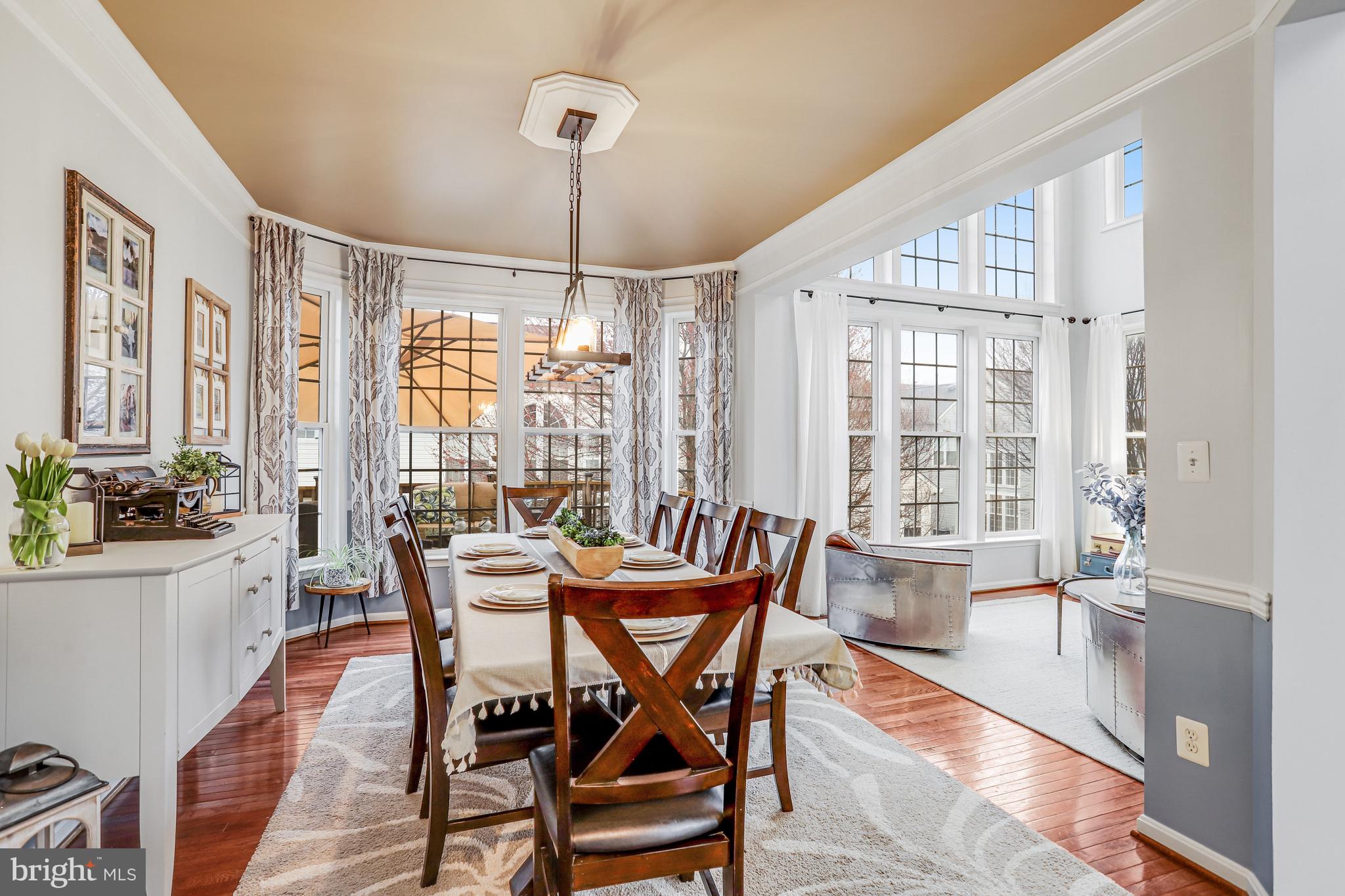 21625 Merion Street Ashburn, VA 20147 - Photo 34 of 80 a dining room with furniture a chandelier and wooden floor