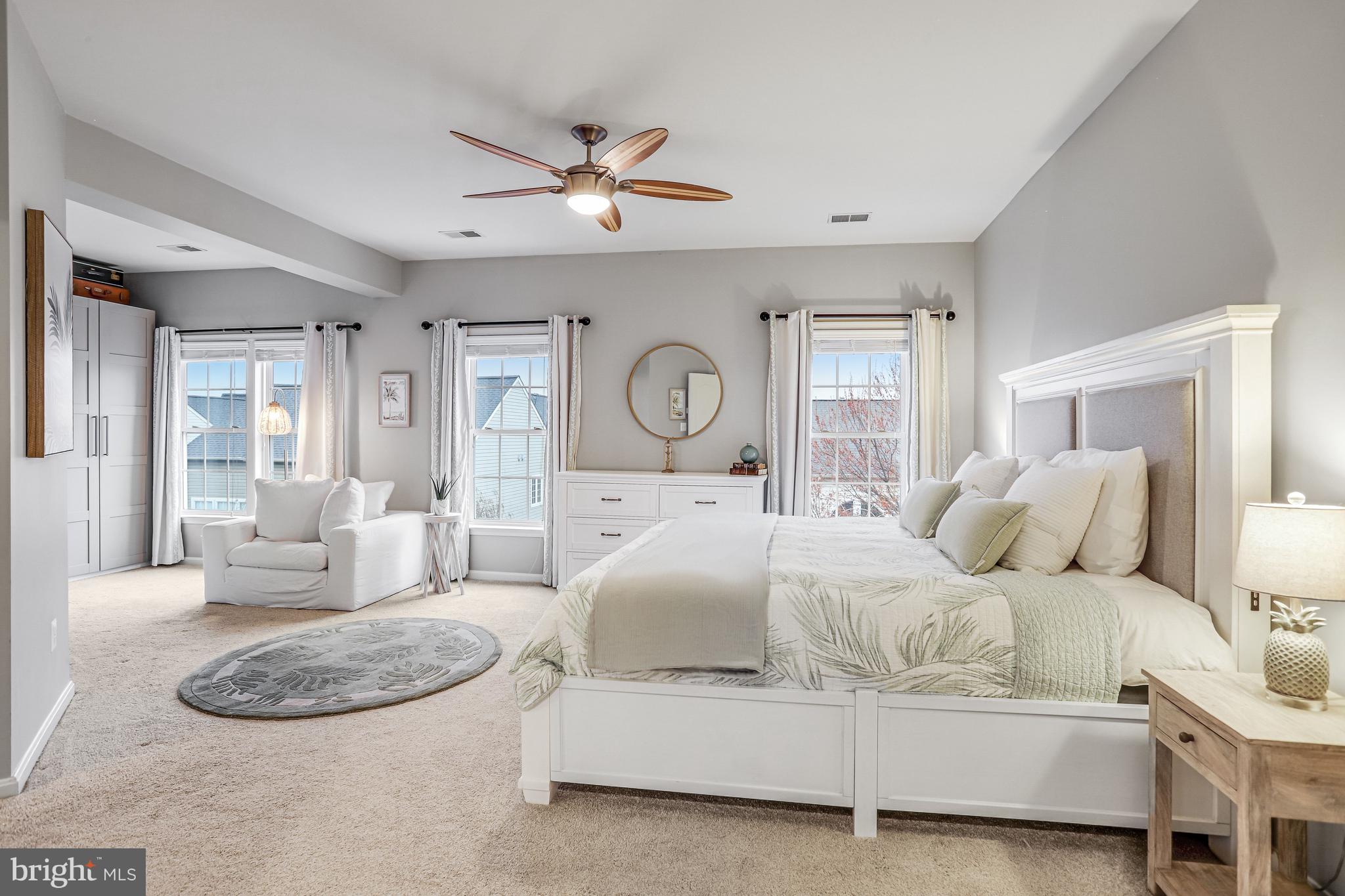 21625 Merion Street Ashburn, VA 20147 - Photo 46 of 80 a bedroom with a large bed and a chandelier
