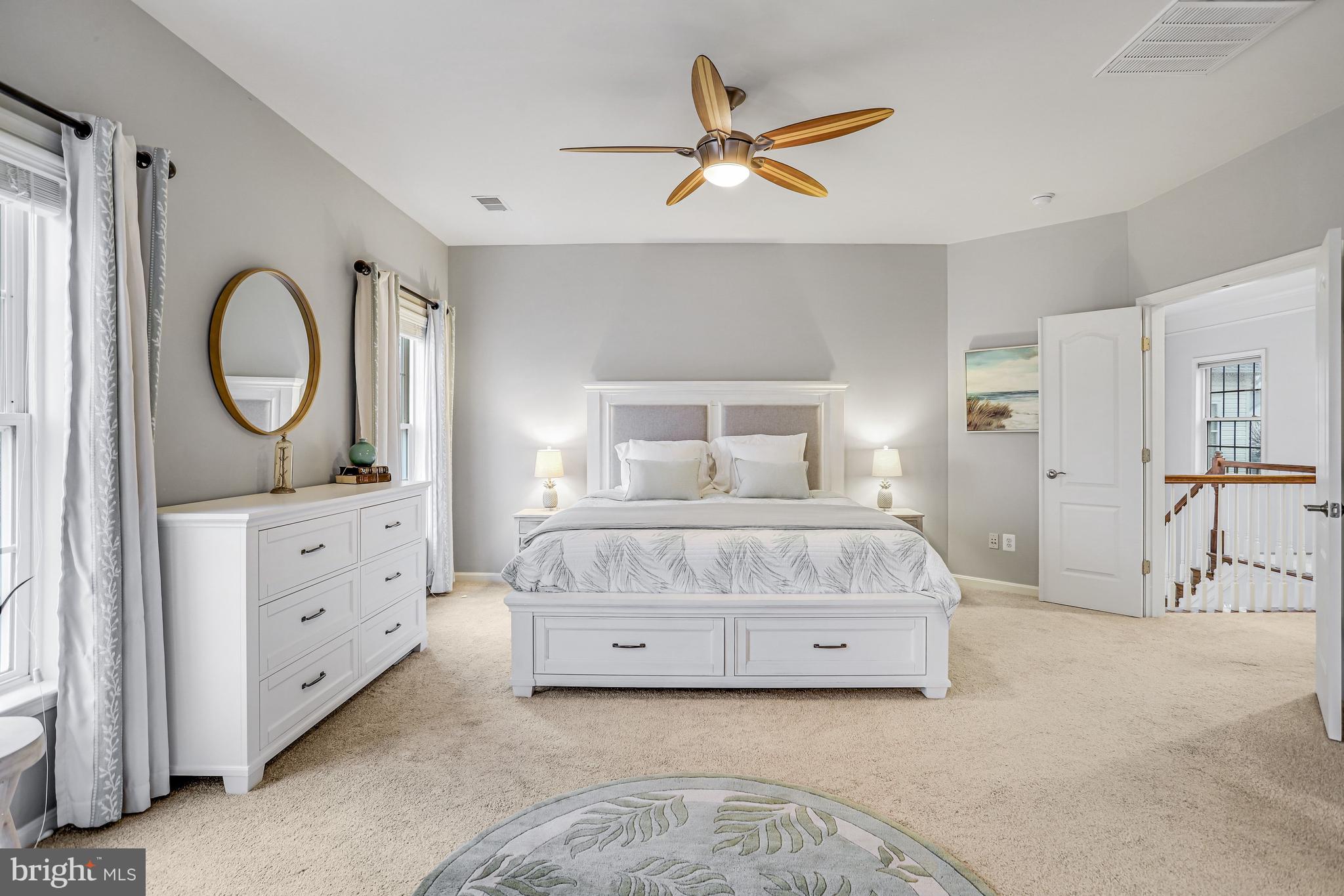 21625 Merion Street Ashburn, VA 20147 - Photo 51 of 80 a bedroom with a large bed and a chandelier