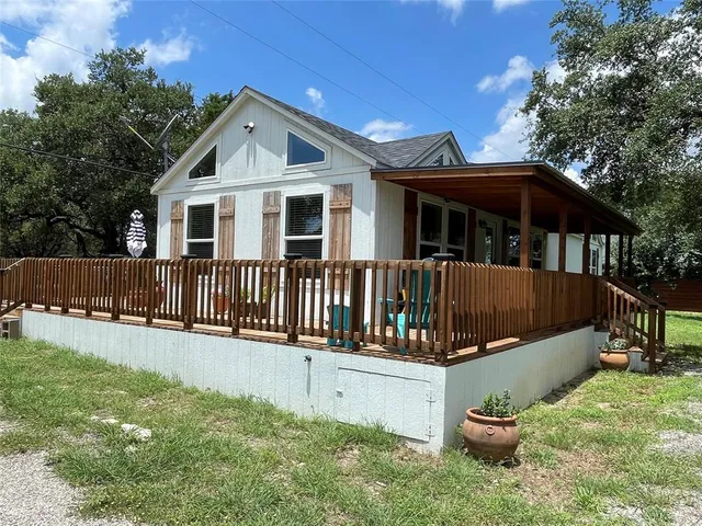 a view of a house with wooden deck and furniture