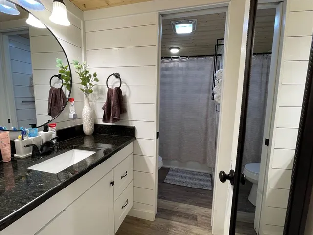 a bathroom with a granite countertop sink a vanity and a mirror