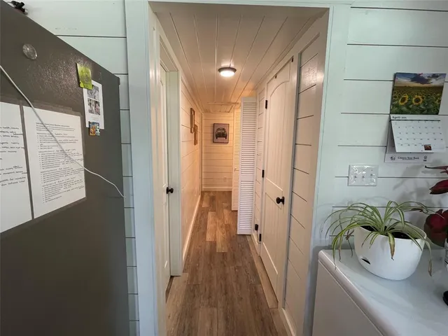 a hallway with a potted plant on the wall and mirror