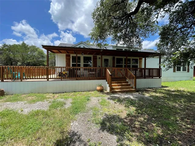 a view of a house with a big yard and a large tree