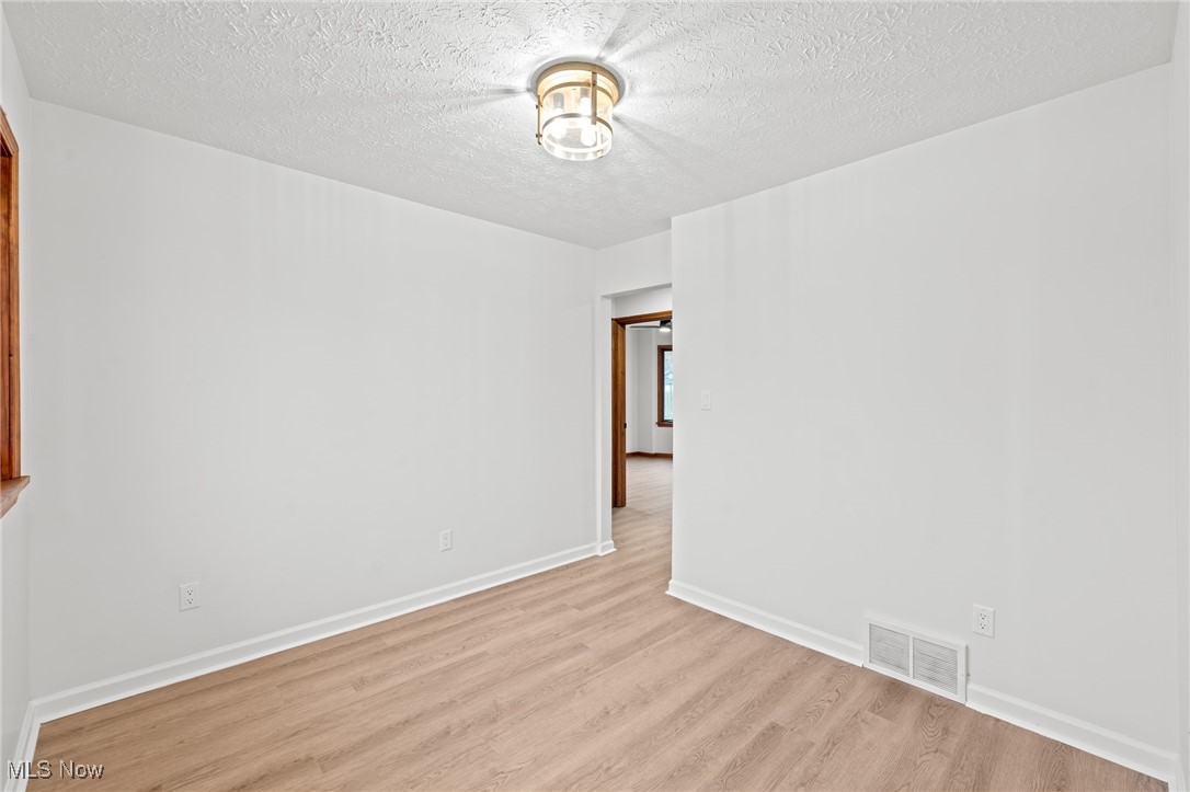 5266 Wilson Mills Road Cleveland, OH 44143 - Photo 8 of 50 Unfurnished room featuring a textured ceiling and light wood-style floors
