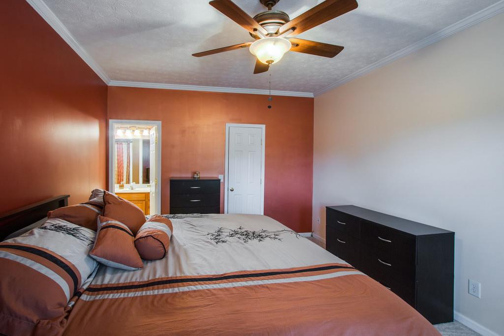 86 Big Springs Road Lebanon, TN 37087 - Photo 16 of 27 a bedroom with a large bed and a chandelier