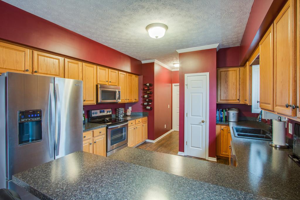 86 Big Springs Road Lebanon, TN 37087 - Photo 10 of 27 a kitchen with stainless steel appliances granite countertop a refrigerator a stove and a sink with wooden floor