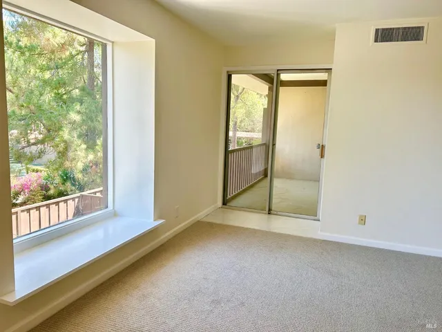 an empty room with sliding glass door and windows