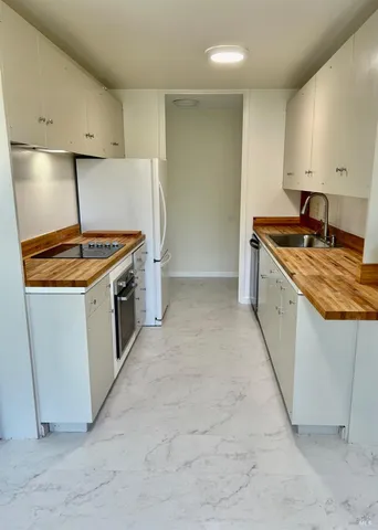 a kitchen with a stove sink and cabinets