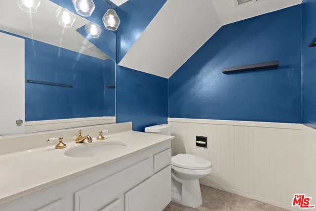 a bathroom with a sink a toilet and mirror