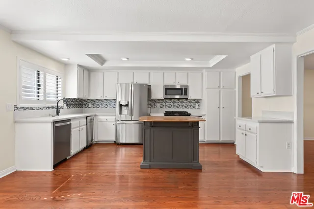 a kitchen with a refrigerator stove top oven and sink