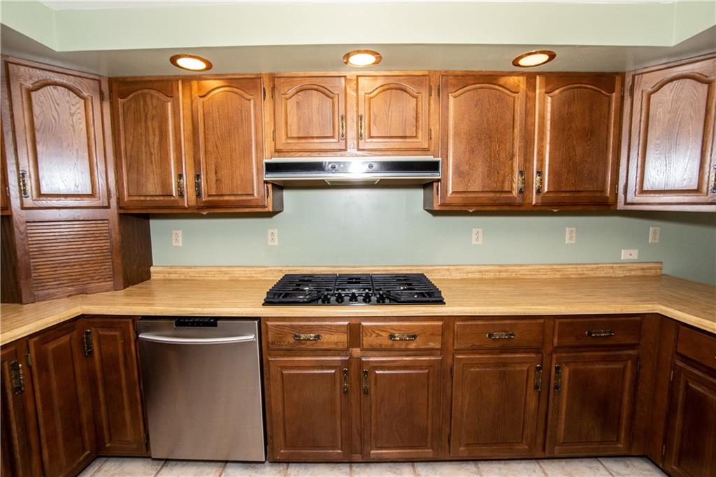 481 South Eberhart Road Butler, PA 16001 - Photo 8 of 25 a kitchen with granite countertop a stove a sink dishwasher and cabinets with wooden floor