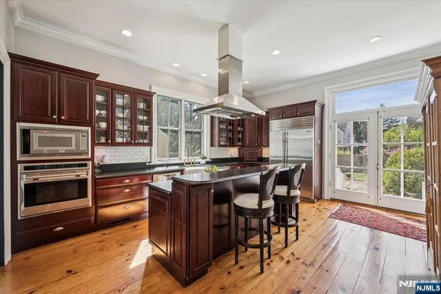 a kitchen with stainless steel appliances granite countertop wooden floor and large window