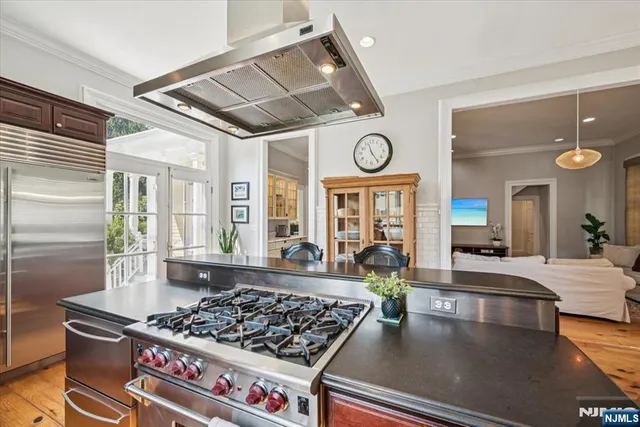 a large kitchen with stainless steel appliances granite countertop a stove and a table