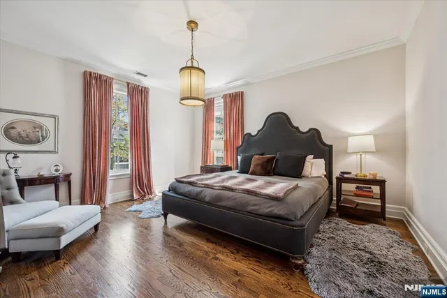 a spacious bedroom with a bed and wooden floor