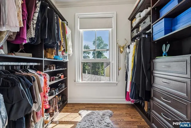 a view of walk in closet with clothes and shoes