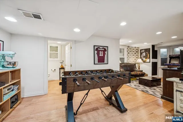 a living room with furniture a flat screen tv and a refrigerator