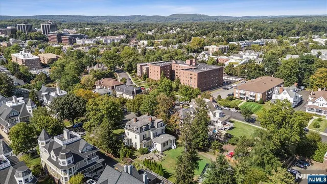 an aerial view of a house with a yard and mountains