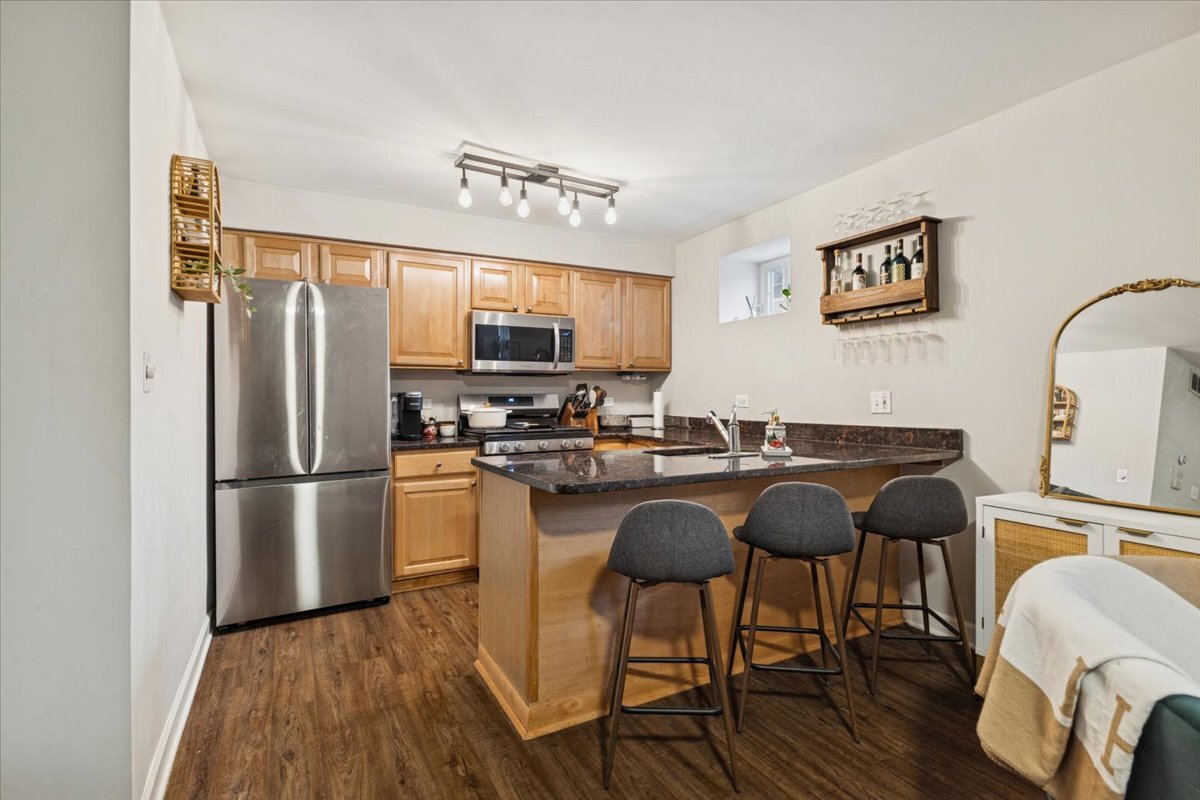 1111 North Honore Street, Unit 1 Chicago, IL 60622 - Photo 3 of 16 a kitchen with stainless steel appliances granite countertop a refrigerator a stove a sink dishwasher a dining table and chairs with wooden floor