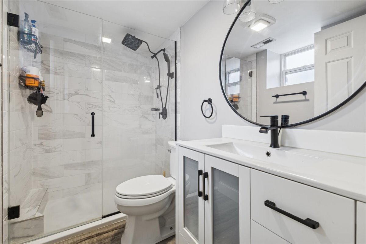 1111 North Honore Street, Unit 1 Chicago, IL 60622 - Photo 8 of 16 a bathroom with a toilet a sink and a mirror