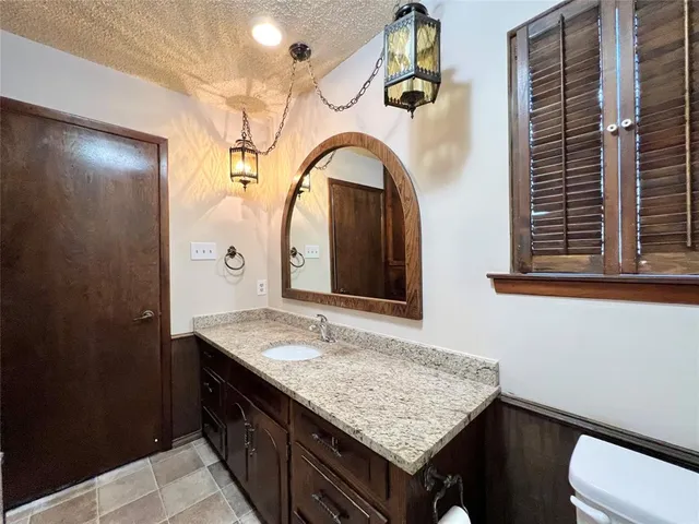 a bathroom with a granite countertop shower a sink and vanity