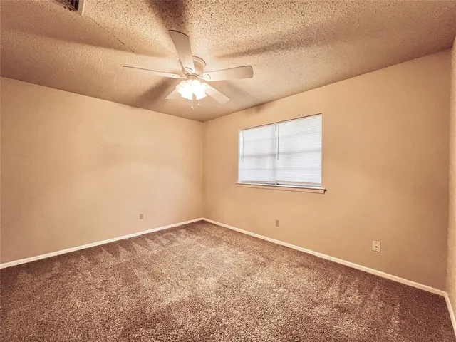 an empty room with closet and a ceiling fan